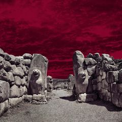 Archäologie: Zwei steinerne Löwenskulpturen an einem Tordurchlass in einer Mauer aus großen Steinquadern