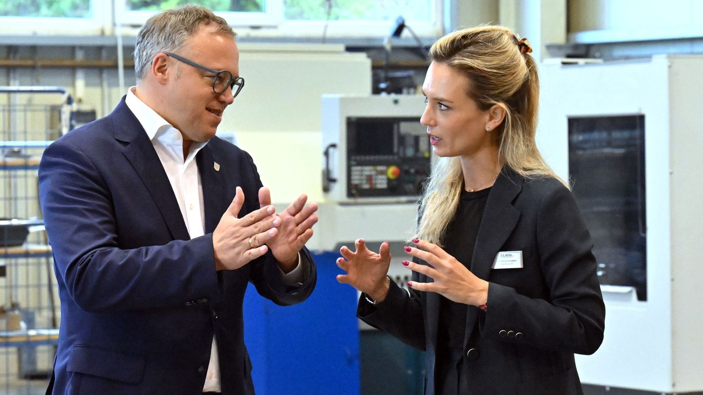 Mario Voigt (l, CDU), Ministerpräsident von Thüringen, spricht mit Karlotta Gründobler, Geschäftsführerin der Eliog Industrieofe