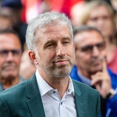 Boris Palmer verfolgt vor dem Streitgespräch eine Anti-AfD-Demo vor der Stadthalle in Tübingen