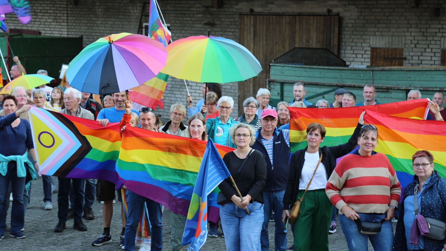 Menschen mit Regenbogenflaggen und -schirmen beteiligten sich an einer Kundgebung. Foto: Benjamin Müller/dpa
