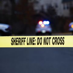 Polizei, Rettungskräfte und ein Absperrband mit der Aufschrift "Sheriff Line: Do Not Cross" – Symbolbild Schuss Illinois