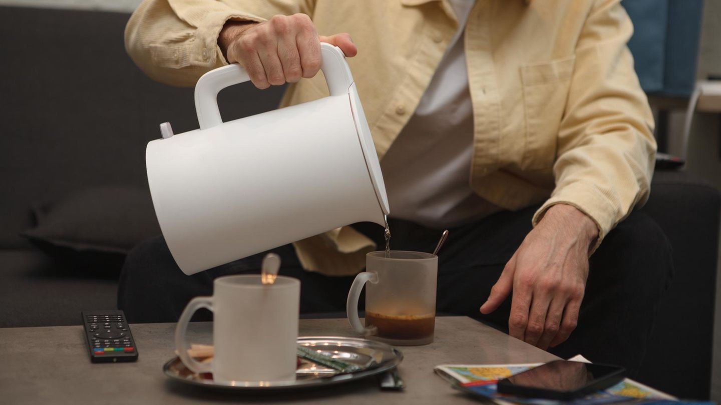 Deals des Tages: Mann gießt sich Wasser aus einem Wasserkocher in eine Tasse