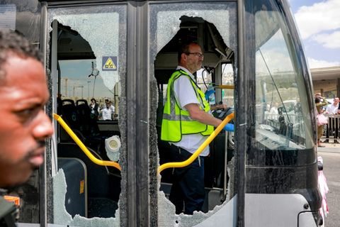 Zerstörte Scheiben eines Busses nahe dem Tatort