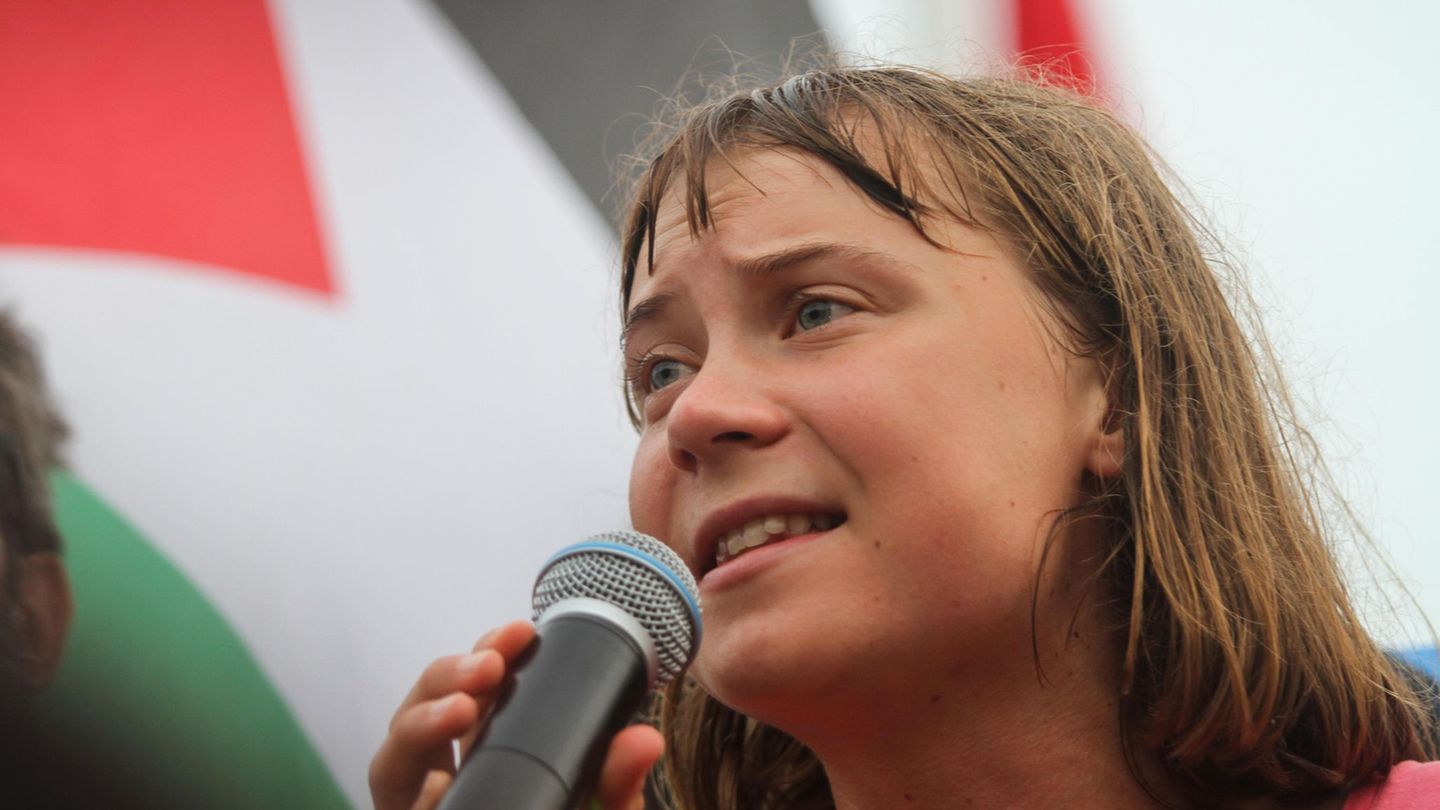 Greta Thunberg schaut ernst und spricht in ein Mikrofon