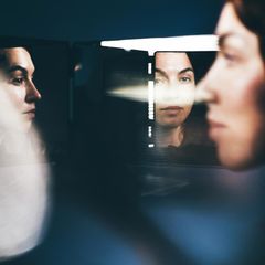 Ein Frauengesicht spiegelt sich aus mehreren Perspektiven in Spiegeln