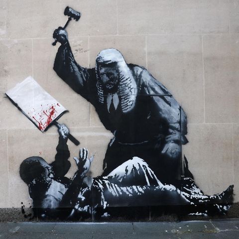 Das neue Banksy Kunstwerk zeigt einen Richter, der auf einen Demonstranten einschlägt