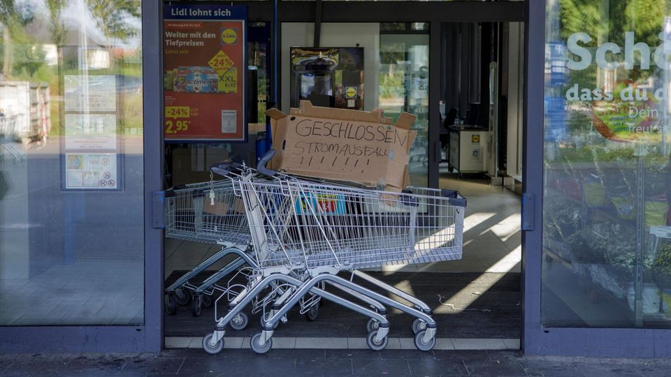 Im Eingang eines Berliner Supermarkts steht ein Einkaufswagen mit einer Pappe mit der Aufschrift "Geschlossen Stromausfall"