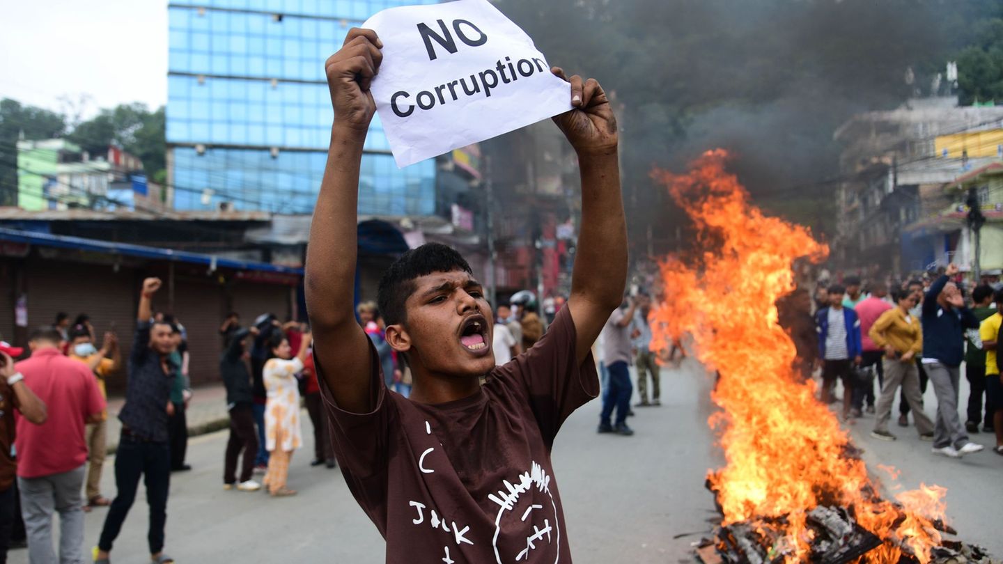Ein Demonstrant in Nepal mit einem Schild, auf der er ein Ende der Korruption fordert