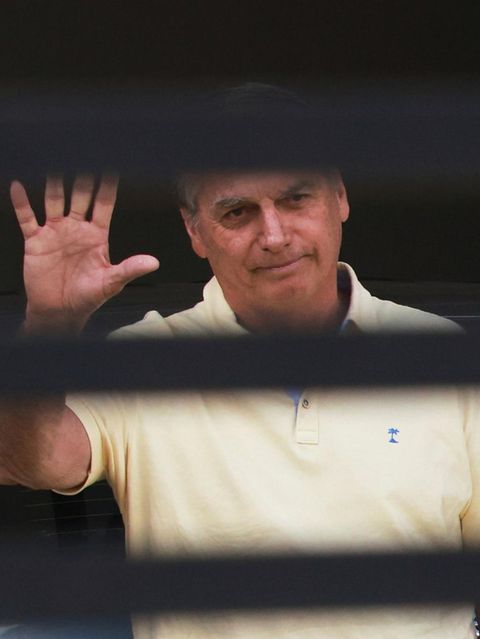 Brasiliens ehemaliger Präsident Jair Bolsonaro winkt hinter dem Eingangstor seines Hauses, in dem er unter Hausarrest steht