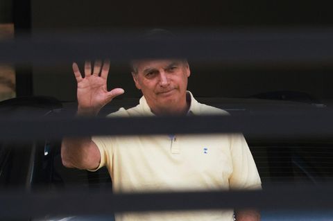 Brasiliens ehemaliger Präsident Jair Bolsonaro winkt hinter dem Eingangstor seines Hauses, in dem er unter Hausarrest steht