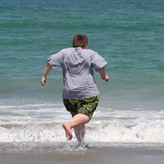 Übergewicht: Ein Junge rennt zum Meer