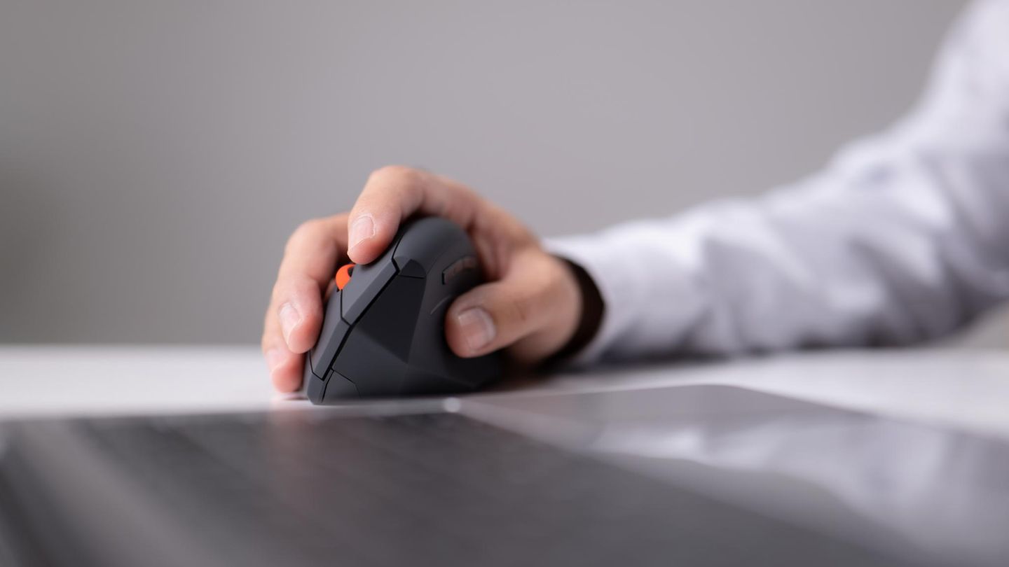 Ein Mann nutzt eine ergonomische Maus im Büro