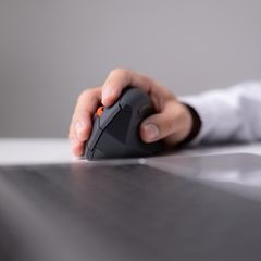 Ein Mann nutzt eine ergonomische Maus im Büro