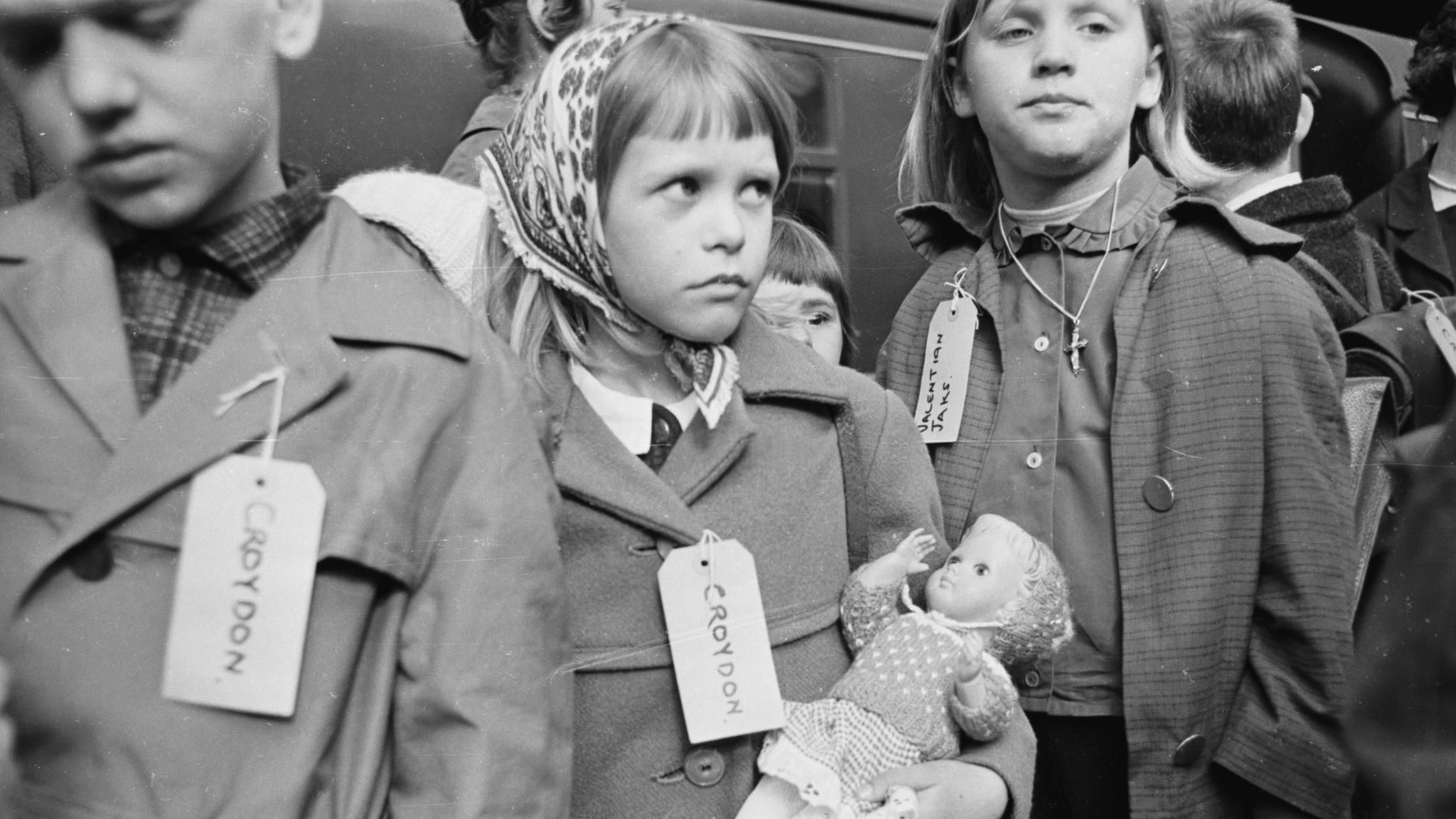 Kinderlandverschickung, junges Mädchen mit Schild Ihrer Familie in England am Bahnhof