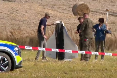 Einsatzkräfte von Polizei und Militärpolizei sichern Teile einer beschädigten Drohne. Foto: Rafal Niedzielski/AP/dpa