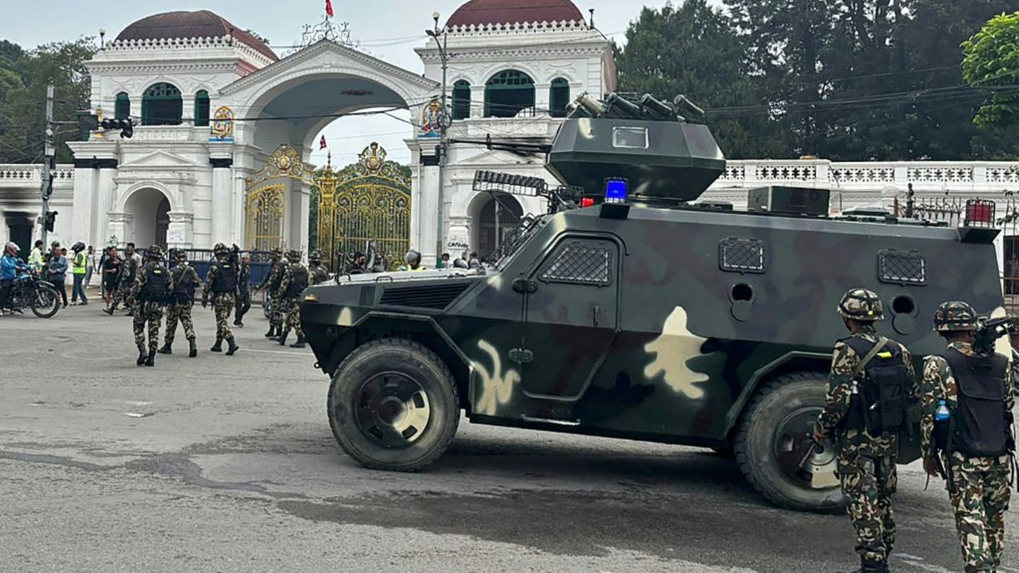 Army personnel patrol along a street outside the Singha Durbar, the main administrative building for the Nepal government, in Ka