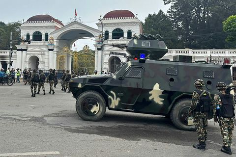 Army personnel patrol along a street outside the Singha Durbar, the main administrative building for the Nepal government, in Ka