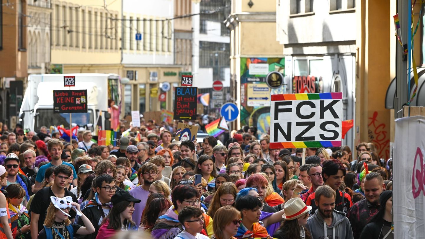 Teilnehmende des CSD ziehen mit Regenbogenfahnen und Plakaten durch die Innenstadt. Foto: Heiko Rebsch/dpa