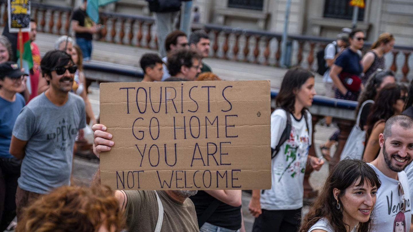 Menschen protestieren im Juli in Barcelona mit Schildern gegen Massentourismus