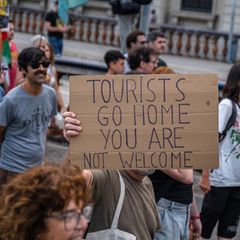 Menschen protestieren im Juli in Barcelona mit Schildern gegen Massentourismus