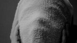 Fotografie: Ein Kind hält sich ein Handtuch vor das Gesicht und hält es mit den Händen. Der Mund ist weit offen