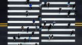Fotografie: Ein Zebrastreifen von oben mit vielen Menschen, die die Straße überqueren