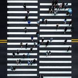 Fotografie: Ein Zebrastreifen von oben mit vielen Menschen, die die Straße überqueren