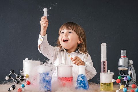 Chemiebaukasten für Kinder: Mädchen staunt über qualmendes Reagenzglas