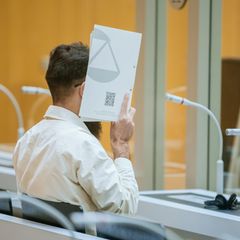 Mannheim-Attentäter Sulaiman Ataee hält sich eine Mappe vor das Gesicht