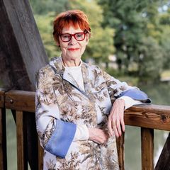 Viktoria Brams, rote Haare, rote Brille, steht auf einer Brücke