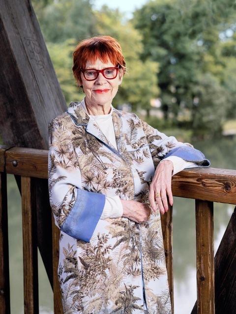 Viktoria Brams, rote Haare, rote Brille, steht auf einer Brücke