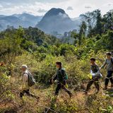 Steinzeit eine Gruppe von Menschen laufen durch grüne Berglandschaft