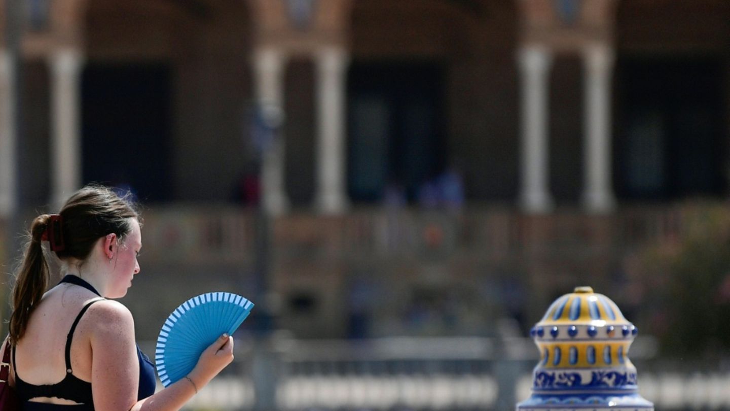 Frau mit Fächer während der Hitzwelle im August in Sevilla