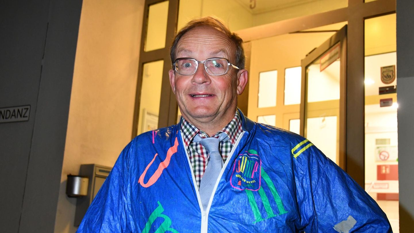 Wigald Boning vor einem Gebäude mit einer bunten Jacke