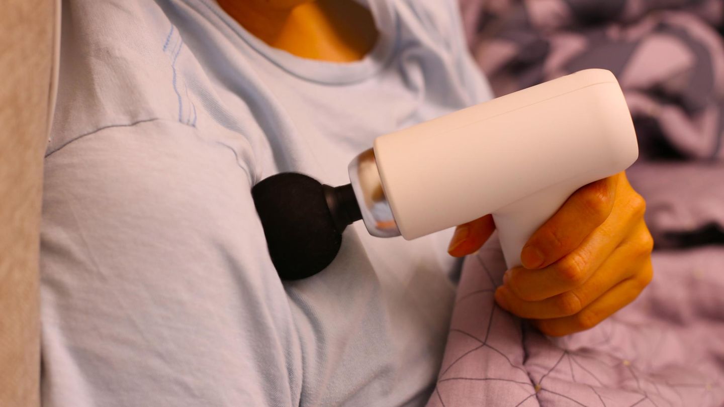 Deals des Tages: Frau behandelt ihre Schulter mit einer Massagepistole
