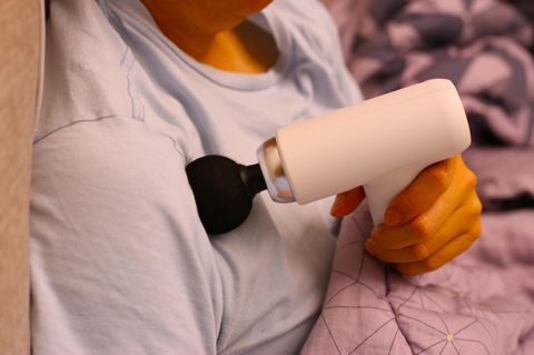 Deals des Tages: Frau behandelt ihre Schulter mit einer Massagepistole