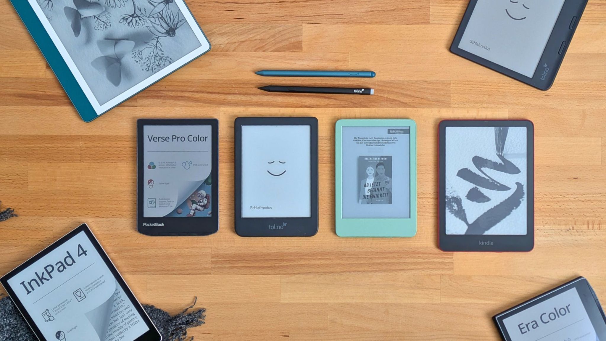 Sieben E-Book-Reader liegen auf einem hellen Holztisch