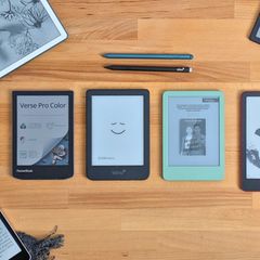 Sieben E-Book-Reader liegen auf einem hellen Holztisch