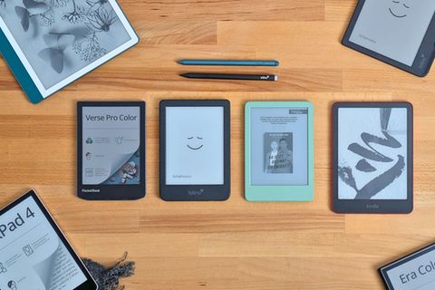 Sieben E-Book-Reader liegen auf einem hellen Holztisch