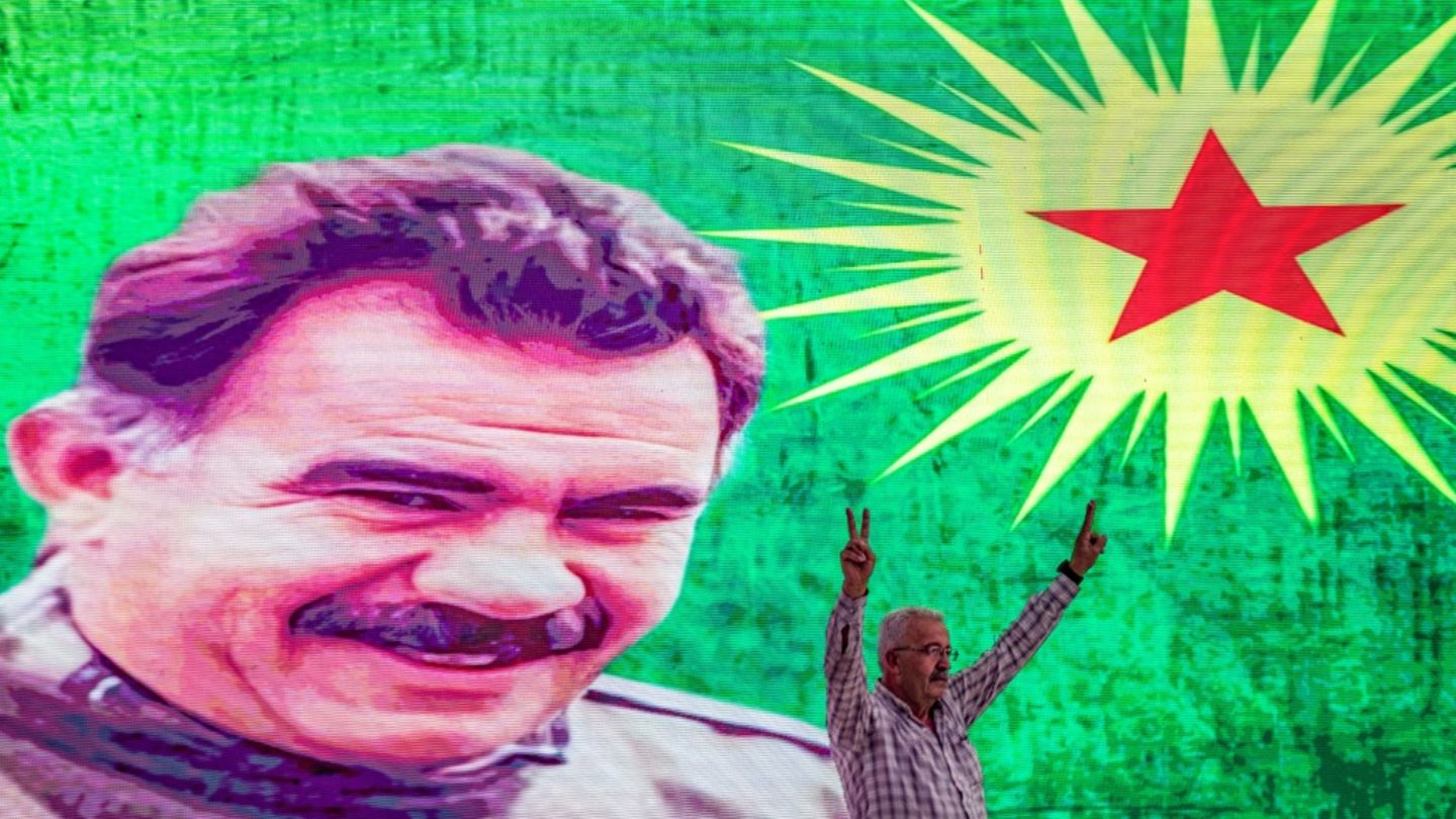 Ein Unterstützer vor einem Großporträt von PKK-Gründer Öcalan