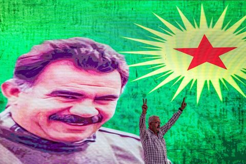 Ein Unterstützer vor einem Großporträt von PKK-Gründer Öcalan