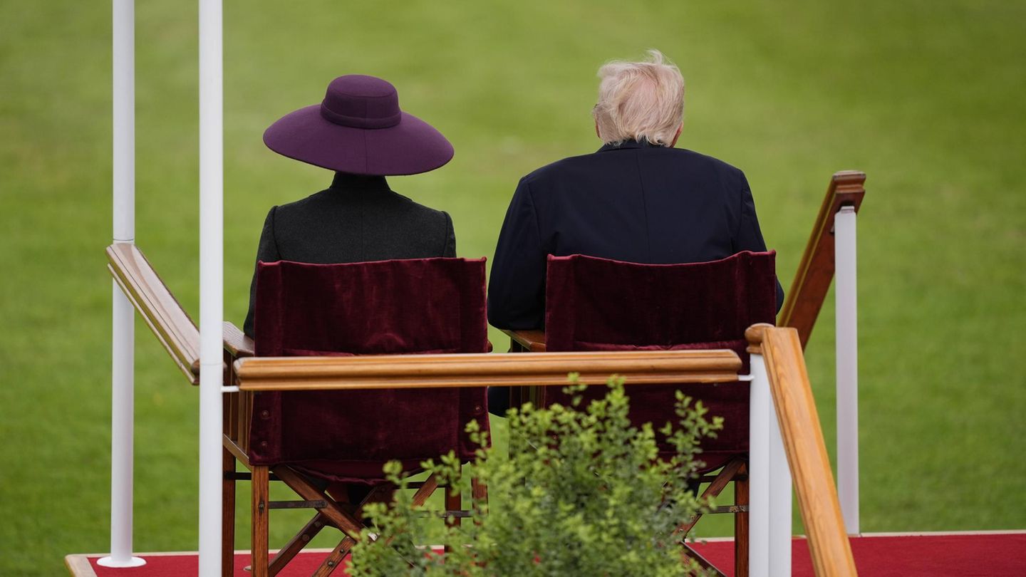 Melania Trump und Ehemann Donald von hinten auf Stühlen sitzend fotografiert