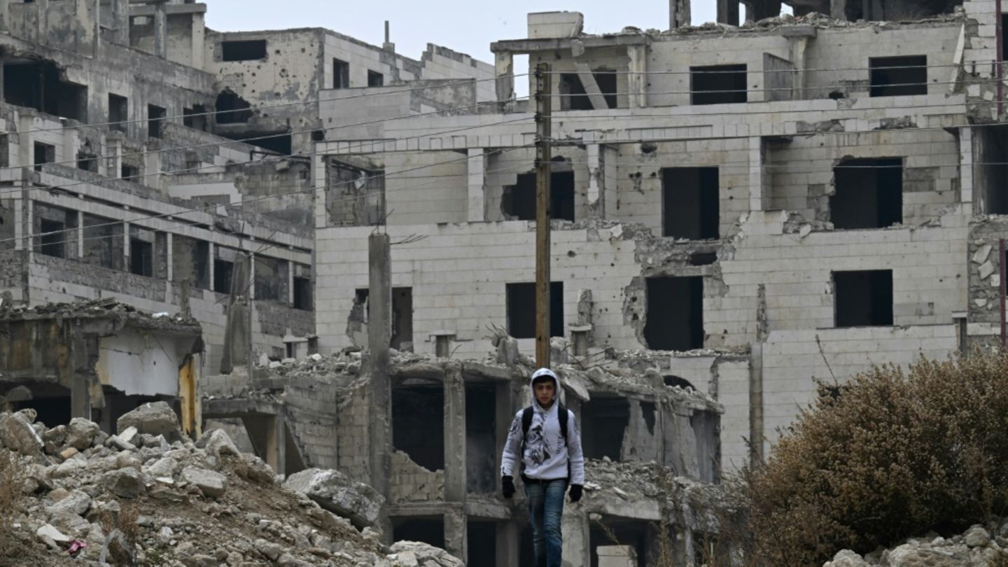 Kind vor Kriegsruinen in Syrien