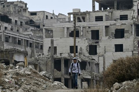 Kind vor Kriegsruinen in Syrien