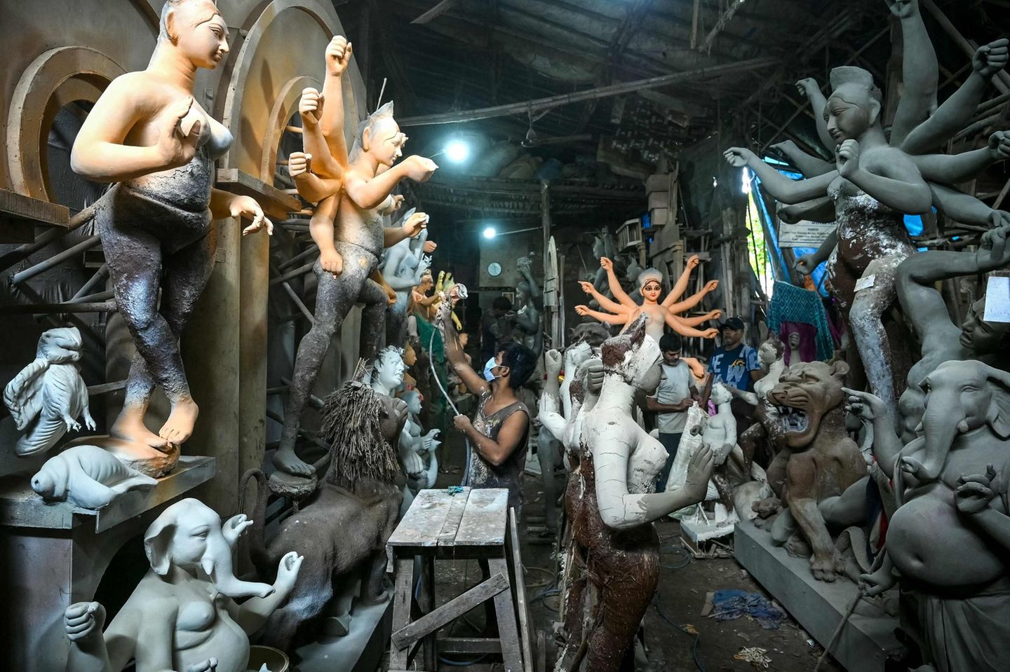 Mumbai, Indien. Ein Künstler bemalt in einer Werkstatt vor dem Durga-Puja-Fest in Mumbai eine Tonfigur der hinduistischen Göttin Durga. Das traditionelle Fest ehrt die Gottheit und feiert den Sieg des Guten über das Böse. Den Höhepunkt bildet ein bunter Umzug, bei dem eine Statue der Göttin in einem Fluss versenkt wird