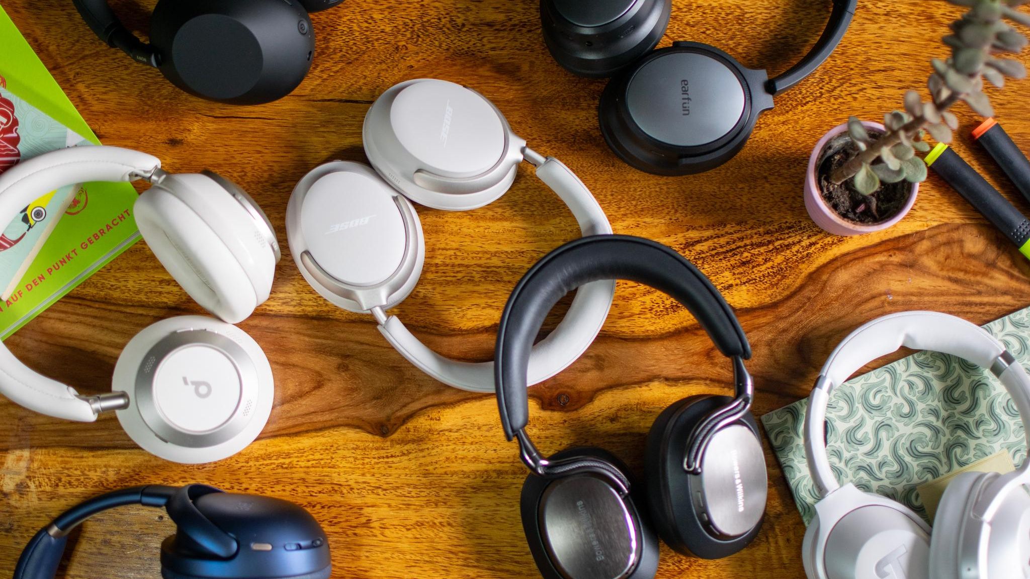 Diverse Over-Ear-Kopfhörerpaare liegen auf einem Holztisch