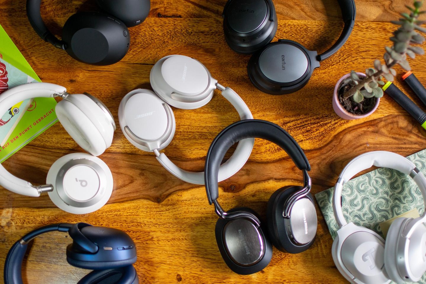 Diverse Over-Ear-Kopfhörerpaare liegen auf einem Holztisch