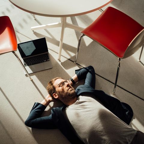 Erschöpfung: Mann liegt mit Laptop auf dem Boden