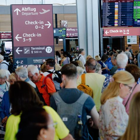 Passagiere warten in einem Terminal am Berliner Flughafen BER