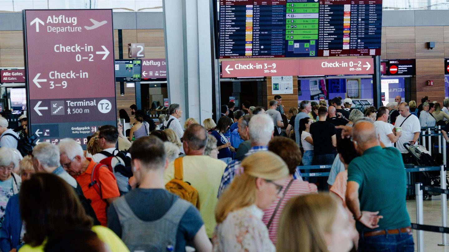 Passagiere warten in einem Terminal am Berliner Flughafen BER
